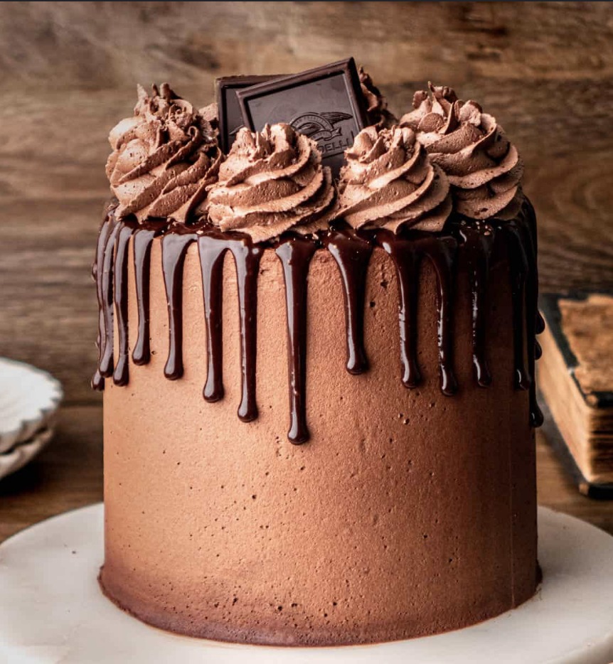 Tall chocolate drip cake with whipped ganache swirls and a dark chocolate bark topper, finished by hand at WARMOVEN